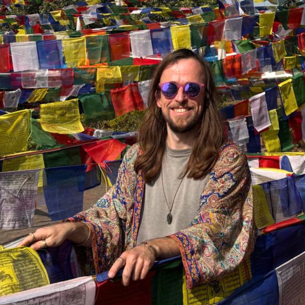 Alex, course host, in front of prayer flags